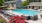 a swimming pool in a courtyard with lounge chairs